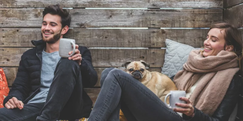 couple sitting outside with a pug