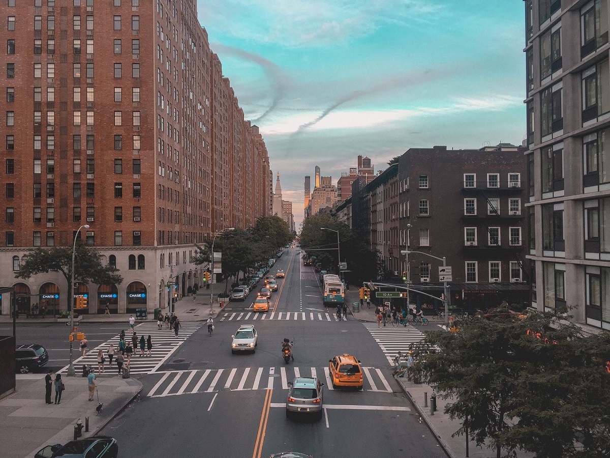 image of city landscape with cars on the street and people walking