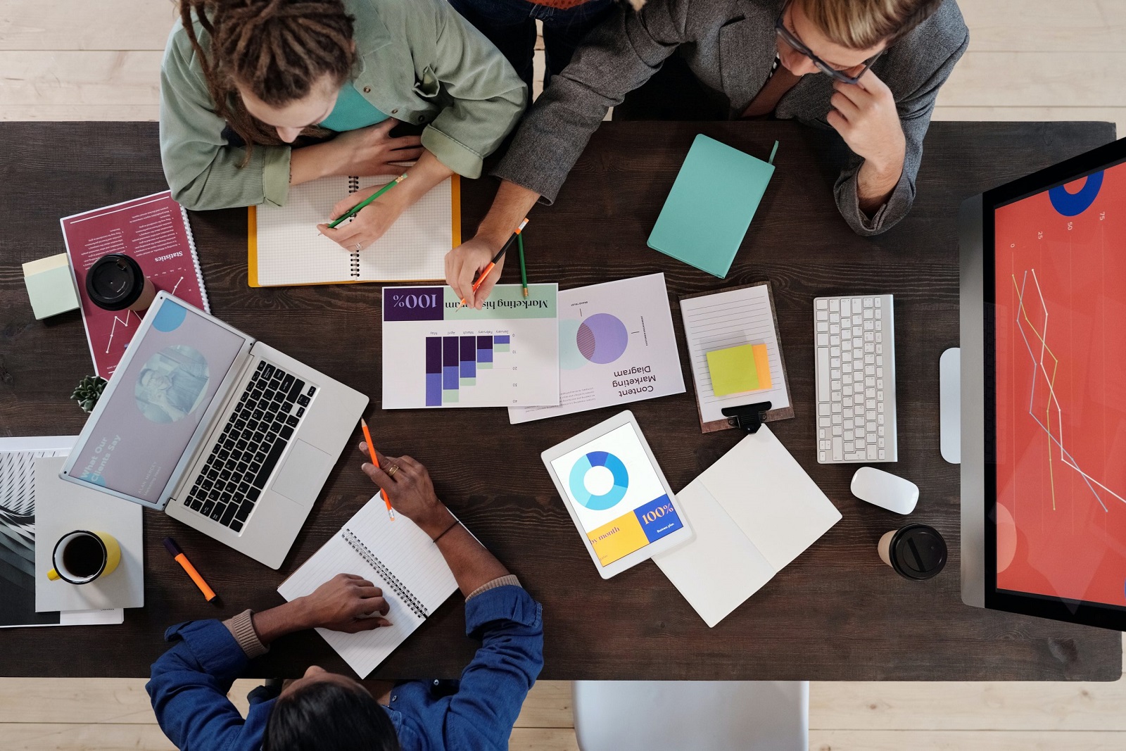 birds eye view of a table with business reports and people discussing.