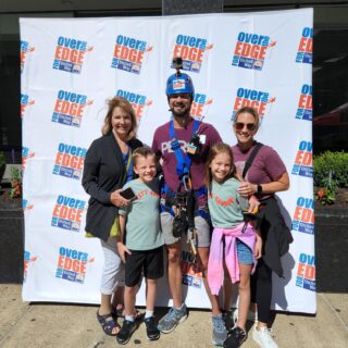 family posing at the Over the Edge for Uniter Way climbing community service event