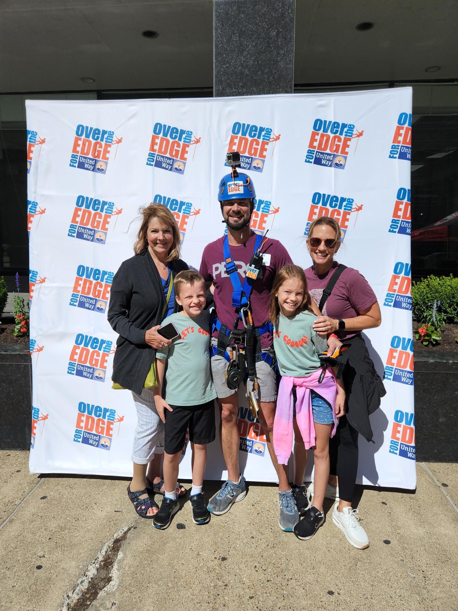 family posing at the Over the Edge for Uniter Way climbing community service event
