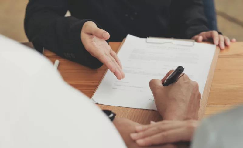 a couple signing a lease agreement with an on-site team member who has availability thanks to automation