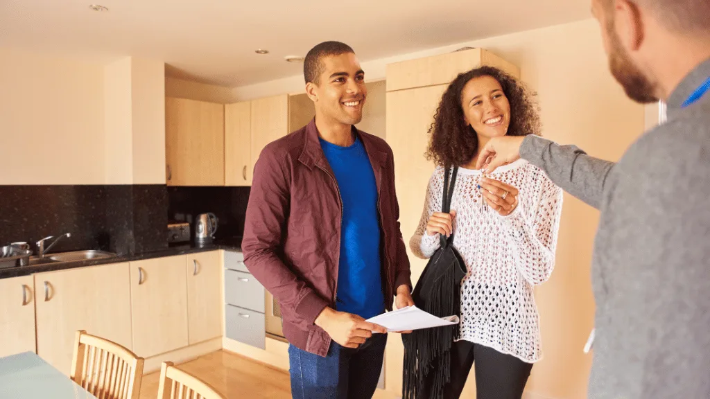 Centralized Leasing and How it Can Unleash the Potential of Your Multifamily Properties | PERQ AI Leasing Assistant a property manager handing over keys to a property to a young couple